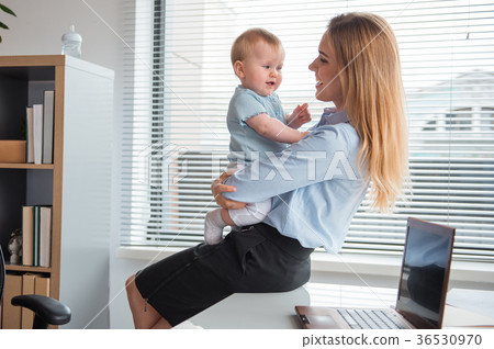 Beaming mother holding cheerful baby on arms Beaming mother holding cheerful baby on arms 36530970