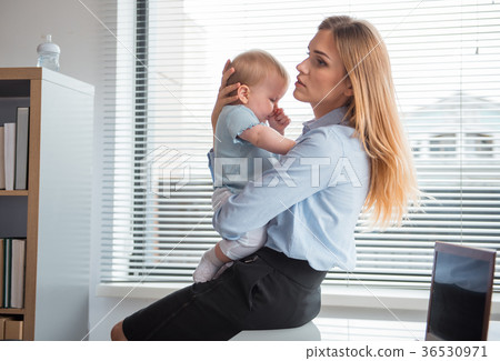 Serious lady keeping orderly kid on arms Serious lady keeping orderly kid on arms 36530971