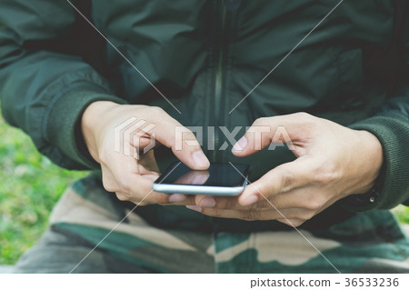 Mid section of military soldier using mobile phone Mid section of military soldier using mobile phone 36533236