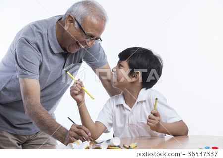 Grandfather and grandson holding painting brush  36537337