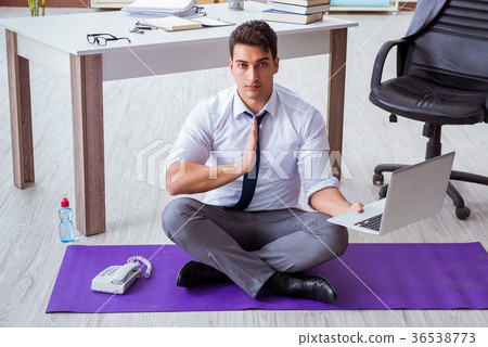 Man meditating in the office to cope with stress 36538773