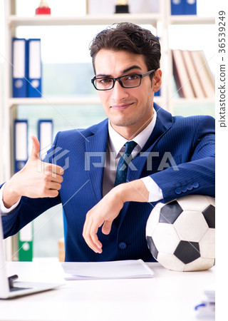 Businessman playing football in the office Businessman playing football in the office 36539249
