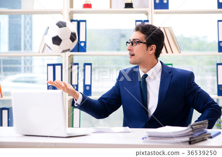 Businessman playing football in the office Businessman playing football in the office 36539250