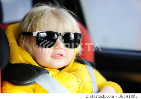 Portrait of cute funny little boy wearing father's sunglasses sitting in car seat Portrait of cute funny little boy wearing father's sunglasses sitting in car seat 36541805