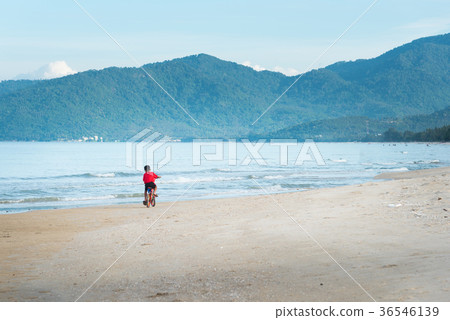 kid boy driving bicycle in the beach 36546139