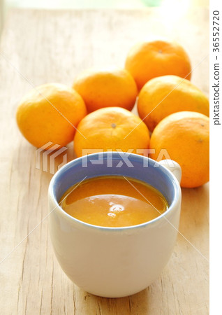 orange juice in cup and tangerine on wooden table 36552720