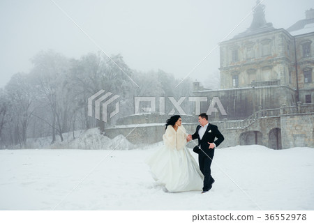 Walking happy newlywed couple along the snowy 36552978