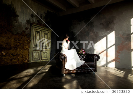 Bride in white dress sitting on chair 36553820