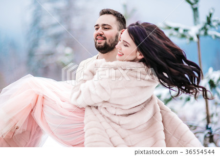 young couple on a walk in the snowy mountains 36554544