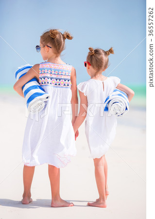 Adorable little girls with beach towels on white Adorable little girls with beach towels on white 36557262