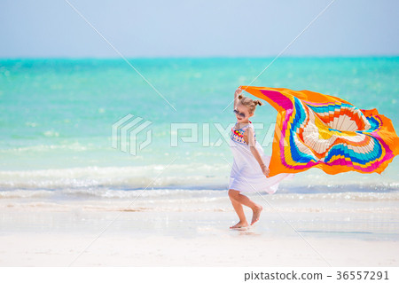 Happy little girl having fun running with pareo on 36557291
