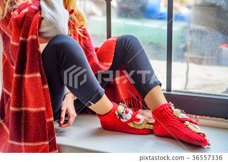 Girl seats on window sill. Cristmas hygge concept. Girl seats on window sill. Cristmas hygge concept. 36557336