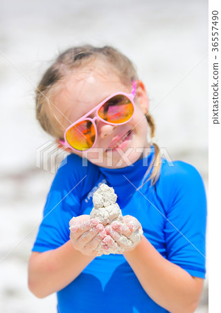 Adorable little girl playing with sand in her 36557490