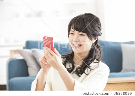 A woman watching a smartphone A woman watching a smartphone 36558059
