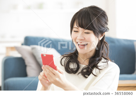 A woman watching a smartphone A woman watching a smartphone 36558060