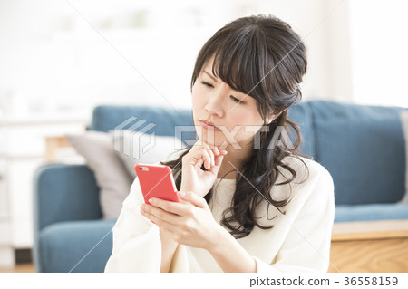 A woman watching a smartphone A woman watching a smartphone 36558159