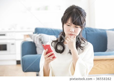 A woman watching a smartphone 36558162