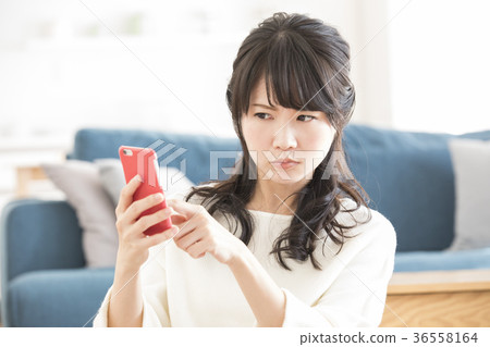 A woman watching a smartphone A woman watching a smartphone 36558164