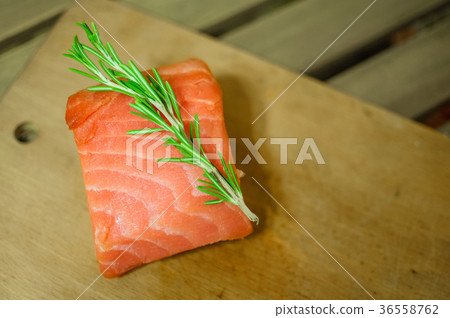 Raw salmon fillet and rosemary on cutting board 36558762