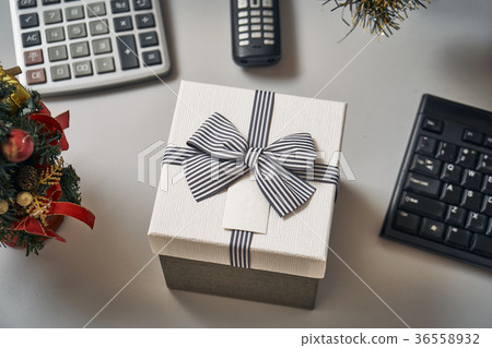 Christmas tree and a gift box on the working place Christmas tree and a gift box on the working place 36558932