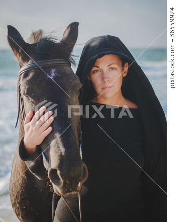 woman stroking and hugging horse at sea beach woman stroking and hugging horse at sea beach 36559924
