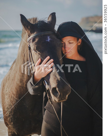 woman stroking and hugging horse at sea beach woman stroking and hugging horse at sea beach 36559925