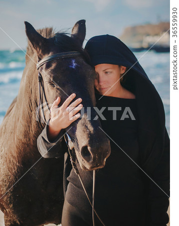 woman stroking and hugging horse at sea beach woman stroking and hugging horse at sea beach 36559930