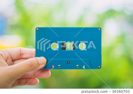 Hand holding a blue retro cassette tape Hand holding a blue retro cassette tape 36560703