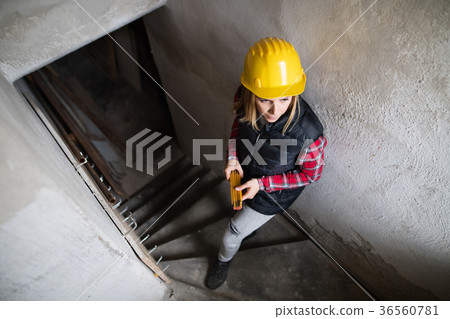Young woman worker on the construction site. Young woman worker on the construction site. 36560781