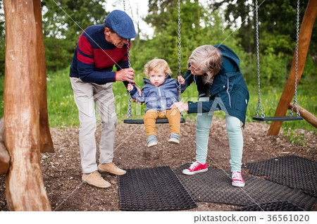 Senior couple with little boy at the playground. Senior couple with little boy at the playground. 36561020
