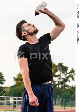 Man drinking from water bottle during sports Man drinking from water bottle during sports 36561535