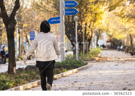 Backside of a Muslim woman walking in a park Backside of a Muslim woman walking in a park 36562323