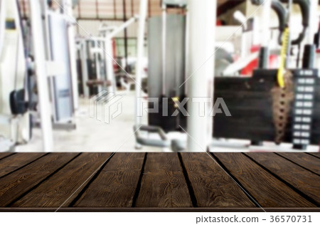Wooden table on blurred background of fitness gym interior of mo Wooden table on blurred background of fitness gym interior of mo 36570731
