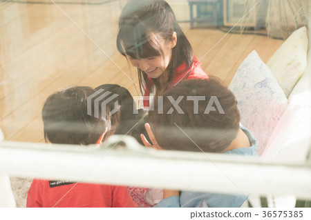 Parents and children relaxing in the living room 36575385