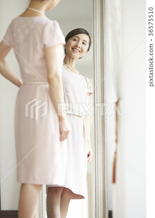 A woman looking at a mirror 36575510