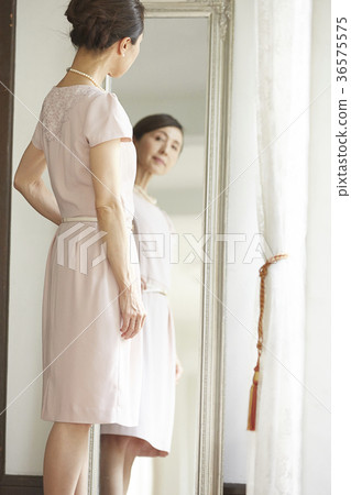 A woman looking at a mirror A woman looking at a mirror 36575575