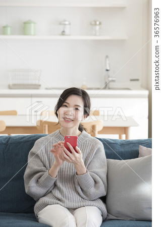Middle woman looking at a smartphone Middle woman looking at a smartphone 36576963