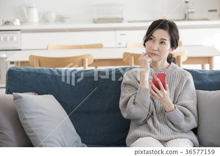 Middle woman looking at a smartphone Middle woman looking at a smartphone 36577159