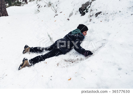 Young boy having fun with snow in the mountain 36577630