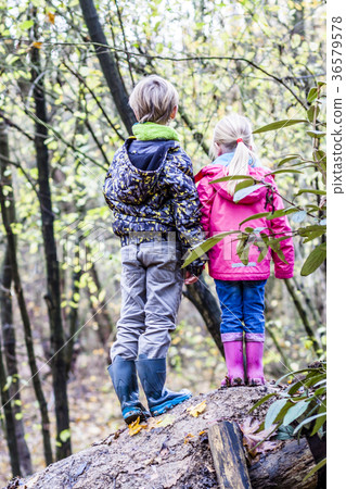 Brother and sister standing hand in hand in the 36579578