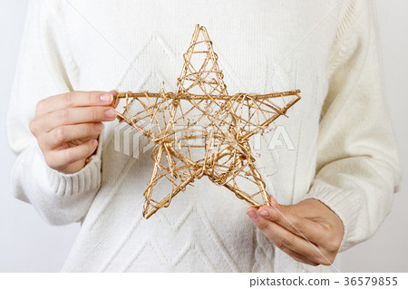 Hands of young woman holding a golden star Hands of young woman holding a golden star 36579855