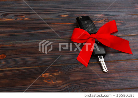Car key with colorful bow on wooden background 36580185