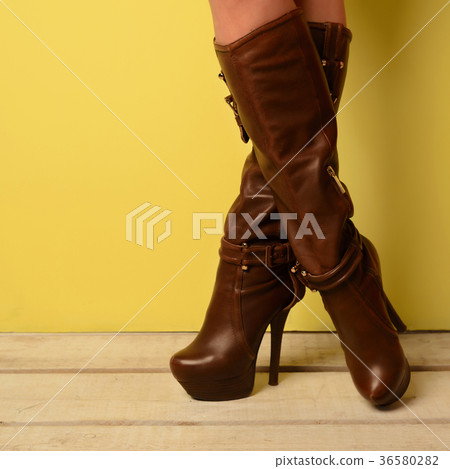 girl in brown spring boots stands cross-legged  36580282