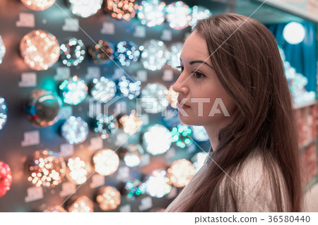 customer girl choosing Christmas tree decorations 36580440
