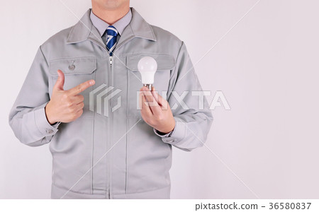 工作服的人指向一個電燈泡的 工作服的人指向一個電燈泡的 36580837