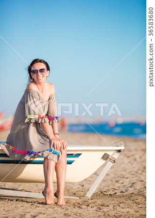 Young beautiful woman on beach during summer Young beautiful woman on beach during summer 36583680