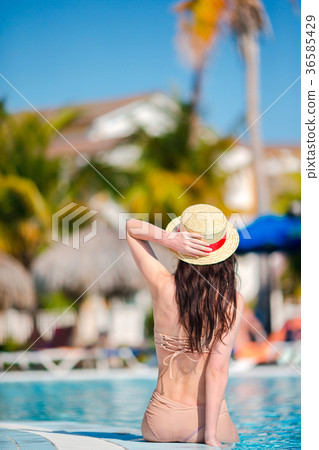 Beautiful young woman relaxing in swimming pool Beautiful young woman relaxing in swimming pool 36585429