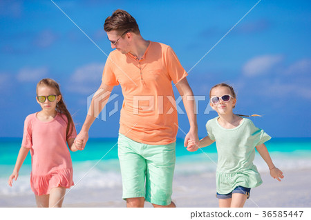 Family of dad and kids walking on white tropical Family of dad and kids walking on white tropical 36585447