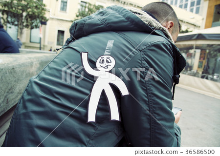 young man with a paper man attached to his back 36586500