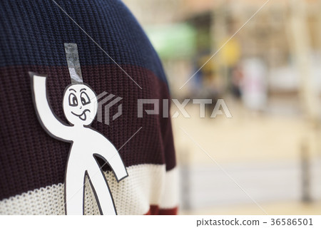 young man with a paper man attached to his back 36586501